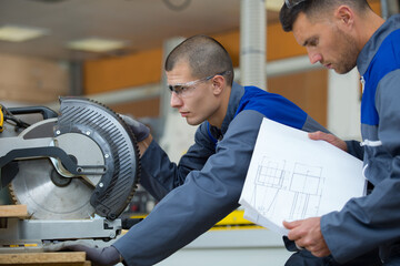 construction worker using slider compound mitre saw
