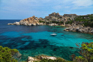 Fototapeta na wymiar Blaue Bucht mit Segelboot bei Capo Testa auf Sardinien am Mittelmeer Italien
