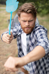 man taking aim with a fly squatter