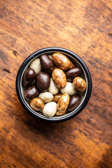 Sweet chocolate almonds. Chocolate eggs in bowl.