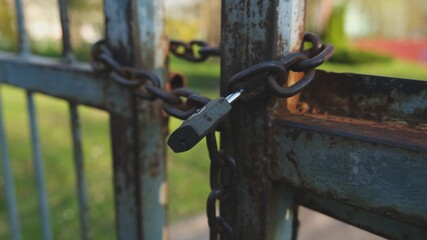 Closed Metal Gate Secured with Iron Chain and Simple Padlock
