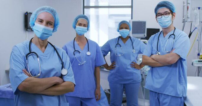 Portrait Of Diverse Female And Male Surgeons Wearing Face Masks And Scrubs In Hospital