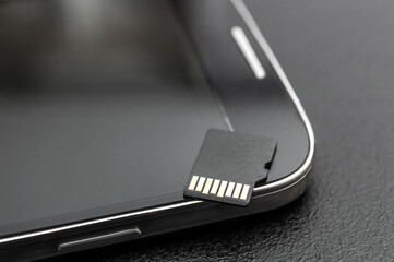 Micro SD memory card with smartphone. Close up.