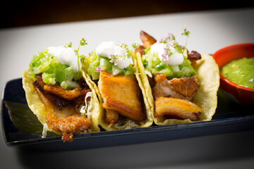 pork belly tacos served with guacamole