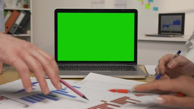 Business partners meeting brainstorming ideas about stock market trading. Leaders working together planning success strategy. Laptop with green screen. Close up. Slow motion ready, 4K at 59.94fps.
