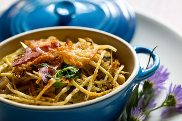 Meat stew with crunchy pasta and bacon on top