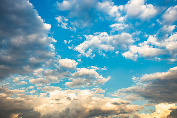 indigo blue sky with white and yellow clouds on the horizon with cotton texture