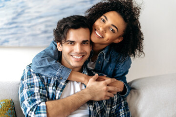 Portrait joyful happy mixed race couple, pretty african american curly girl tenderly hugging her...