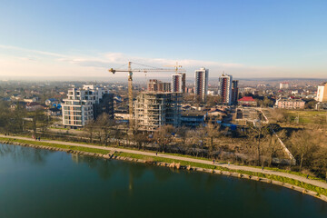 Aerial view of high tower crane and residential apartment buildings under construction. Real estate development.