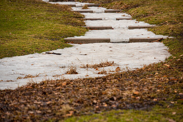 Small stream in a park separated into small steps. Frozen water in winter..