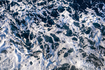 Top down aerial view of sea water surface. White foam waves texture as natural background.