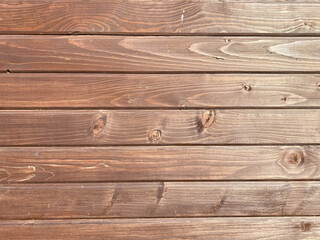 Fototapeta premium Beautiful wooden texture of horizontal multi-colored boards with knots on a brown wall surface. The background. Texture