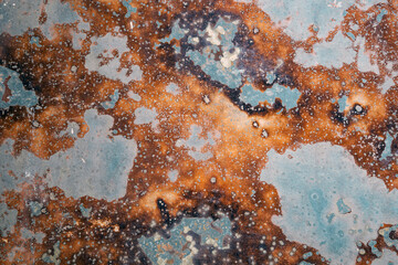Corrosion. Vintage plate with weathered colors and rust. Spotted blue, brown and orange metal...