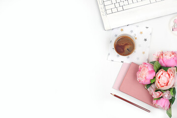 Modern woman working desk, home office. Computer, a cup of coffee and spring flowers on a light table. Business minimal concept, home comfort, top view, flat lay, place for text