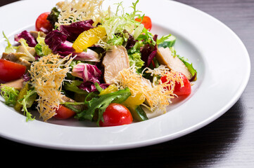 fresh vegetable salad and smoked poultry, garnished with grilled cheese and orange slice