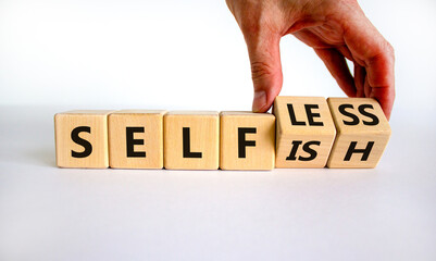 Selfish or selfless symbol. Businessman turns cubes and changes the word 'selfish' to 'selfless'. Beautiful white background, copy space. Business, psuchological and selfish or selfless concept. - obrazy, fototapety, plakaty