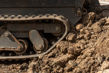 Rubber tracks of a construction machine in a pile of dirt..