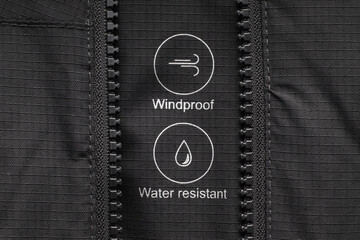 Water resistant and windproof symbols on black clothing. The choice of suitable clothing for the...