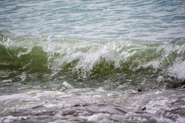 sea landscape is a pebbly beach with waves in white foam