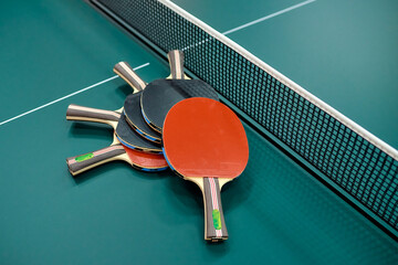 pingpong rackets lie on a green pinpong table