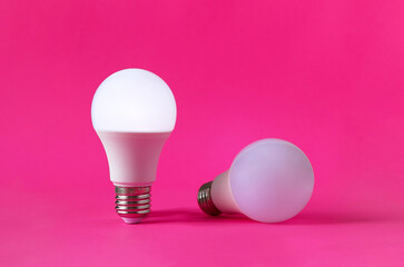 Bright and dim light bulbs on magenta background. Concept of occupational burnout