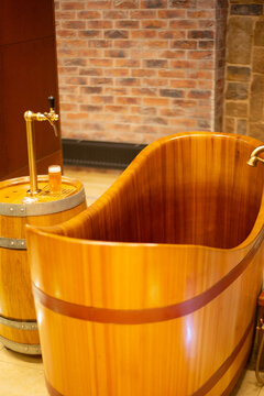 Pilsen, Czech Republic, 1.09.2019 - Empty Wooden Bathtub at Beer Spa. Beer tasting mug and copper faucet for filling beer bath copy space. Exotic beer spa concept