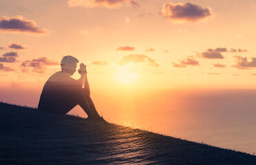 Praying man in a beautiful sunrise setting. 