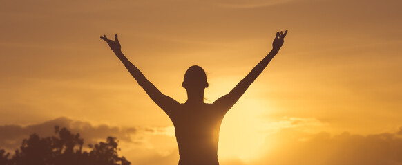 Happy woman with hands up to the sunset sky. Positive energy, prayer and gratitude concept.	