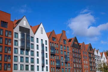 Urban buildings in a row against a blue sky.
