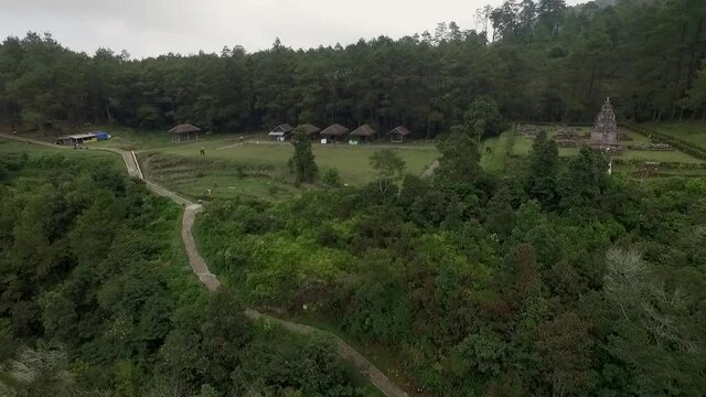 Bandungan tourist place showing isolated ancient Hindu temple and sidewalk. View from drone flying trucking movement from left to right