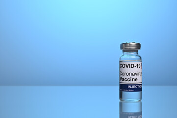 Covid vaccine vial with copyspace on blue gradient background. Covid-19 vaccination jar. Covid inoculation photo for healthcare promotion. Vaccines are effective in coronavirus and flu treatment.