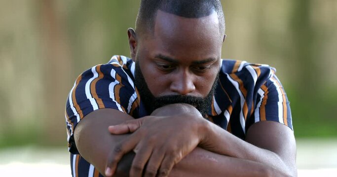Depressed African man feeling loneliness. Preoccupied pensive black person