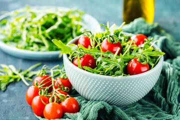 close-up view of fresh salad with tomatoes and arugula on table