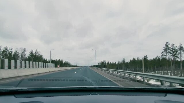 driving in a car along the highway to the port of Ust-Luga on a spring day