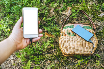 Mockup of a smartphone in a guy's hand. Against the background of the Power Bank and the Gorzina on...