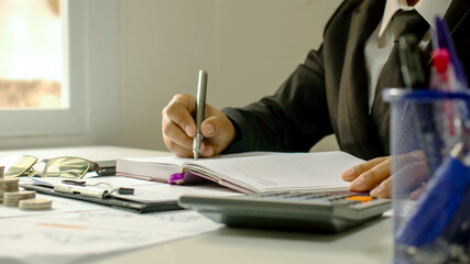 Close-up of a business man taking notes on accounting reports, ideas for costing and saving money.