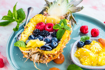 Fototapeta na wymiar top view of gourmet dessert with halved pineapple and fresh berries on table 