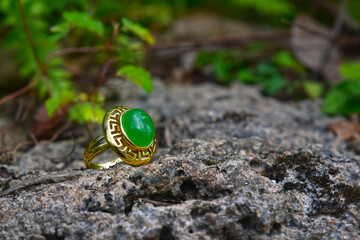 A golden ring decorated with jade placed on the ground.
