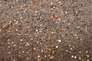 Coins at the bottom of the well. Coins of various denominations among the rubble at the bottom of a dry well.