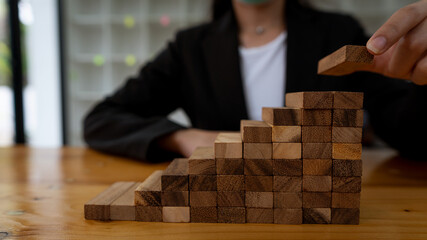 Arrange the wooden blocks stacked on the table. Construction business risk concepts For a...