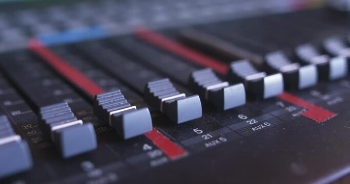 Mixing desk volume faders, extreme closeup, slider shot from recording studio