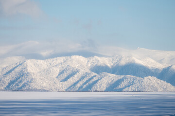 Obraz na płótnie Canvas 北海道の冬景色 雪原の影と山の風景 