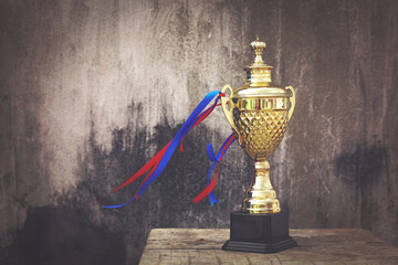 Gold winners trophy or champion cup on wooden table