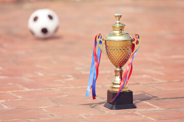 Gold winners trophy or champion cup with Football on floor 