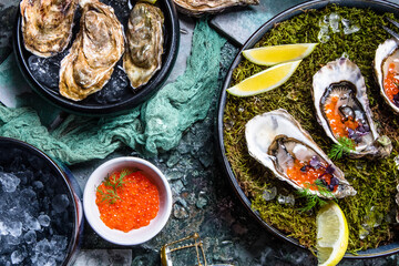 Top view of delicious oysters on ice with lemon and salmon caviar.