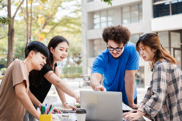 Happy Group of attractive young people using a laptop and tutoring together on study table, Social media online concept and Youth student and tutoring education with technology learning concept.