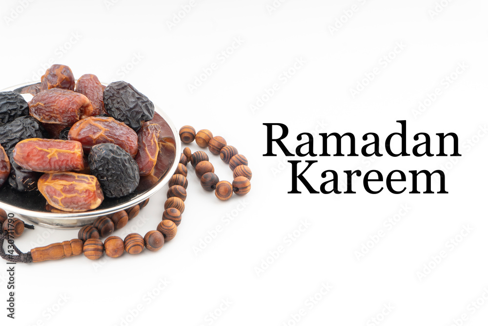 Wall mural ramadan kareem text with dates or kurma fruits and rosary beads or tasbih on white background. ramad