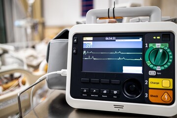 Monitor screen for medical defibrillator or emergency heart pump,showing vital signs,heart rate,slow beating pulse of a dying coma patient in a hospital ICU room or deaths from Coronavirus COVID-19 - obrazy, fototapety, plakaty