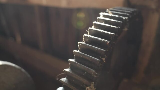 Old rusted machine cog wheel in orbit shot in low sunlight.