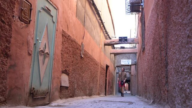 A young man explore the narrow streets of Marrakesh medina imperial pink city